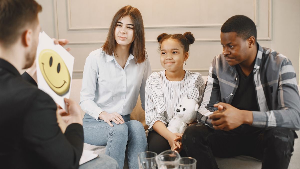A family therapy session with a therapist, featuring parents and a child engaging in discussion.